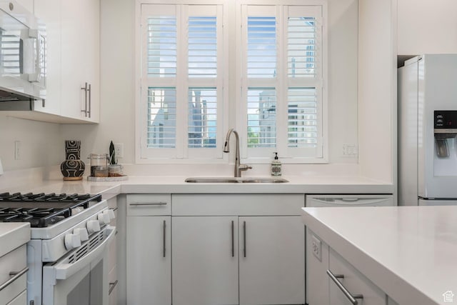 kitchen with white appliances, a sink, and light countertops