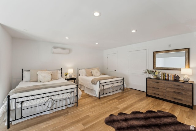 bedroom featuring light wood finished floors, a wall mounted AC, and recessed lighting
