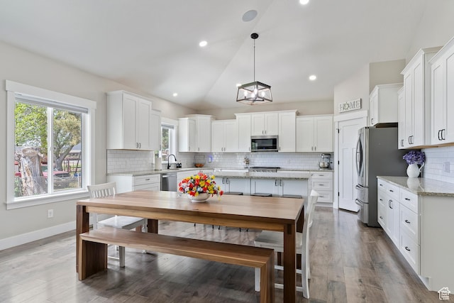 2685 N 850 E, North Ogden, UT 84414 - kitchen featuring stainless steel appliances, white cabinetry, healthy amount of natural light, vaulted ceiling, and recessed lighting