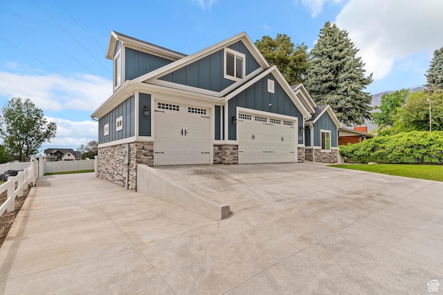 2685 N 850 E, North Ogden, UT 84414 - view of front of property with board and batten siding, stone siding, fence, a garage, and driveway
