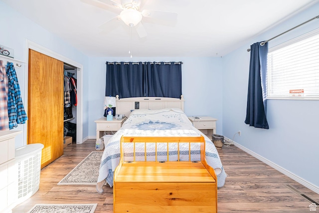 bedroom with wood finished floors, a closet, baseboards, and a ceiling fan