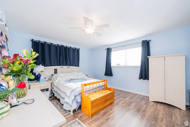 bedroom featuring wood finished floors, baseboards, and ceiling fan