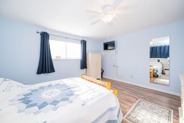 bedroom with wood finished floors, baseboards, and a ceiling fan