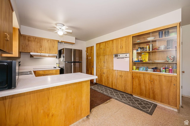 kitchen with black appliances, under cabinet range hood, ceiling fan, a peninsula, and brown cabinetry
