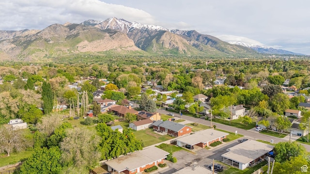 aerial view of property's location with a mountainous background and nearby suburban area