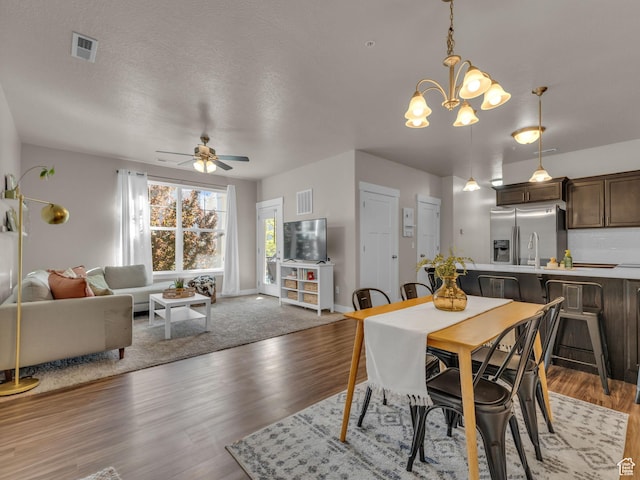 14642 S Mckellen Dr Unit 201, Herriman, UT 84096 - dining area with ceiling fan, wood finished floors, a chandelier, a textured ceiling, and baseboards