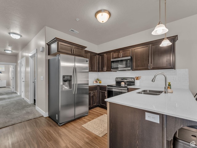 14642 S Mckellen Dr Unit 201, Herriman, UT 84096 - kitchen featuring stainless steel appliances, a sink, dark brown cabinets, light wood-style flooring, and tasteful backsplash