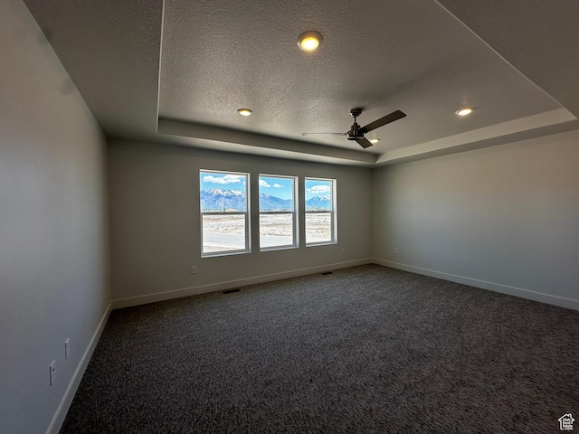 carpeted spare room with a raised ceiling, a textured ceiling, baseboards, ceiling fan, and recessed lighting