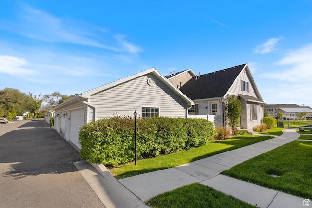 view of home's exterior with a yard, driveway, and an attached garage