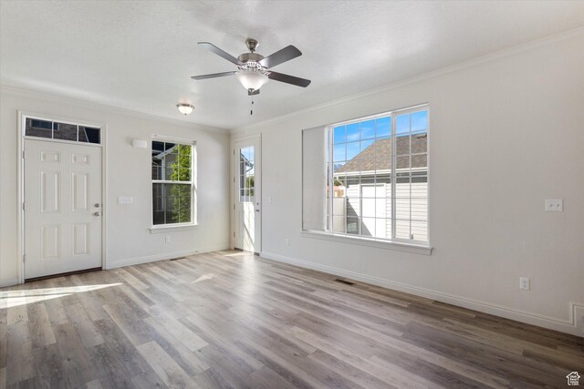 foyer entrance featuring crown molding, ceiling fan, wood finished floors, and baseboards