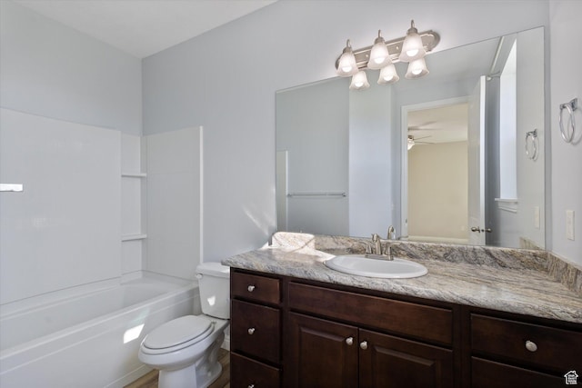 bathroom with vanity, toilet, a ceiling fan, and shower / washtub combination