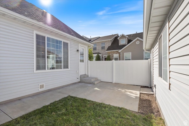 view of patio featuring fence, entry steps, and a residential view
