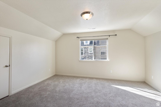 additional living space featuring vaulted ceiling, carpet flooring, and baseboards