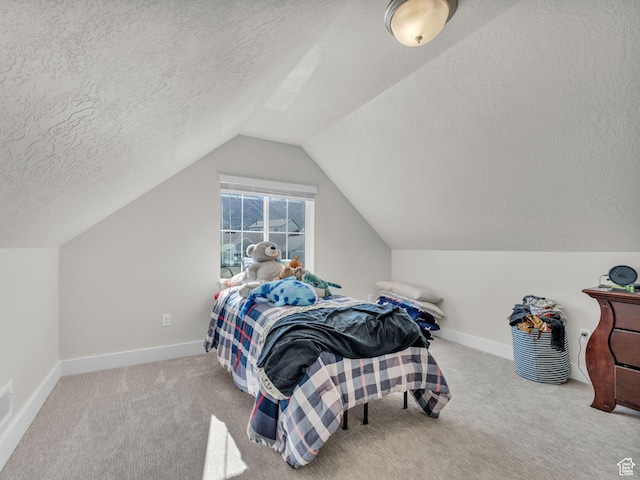 bedroom with a textured ceiling, vaulted ceiling, carpet flooring, and baseboards
