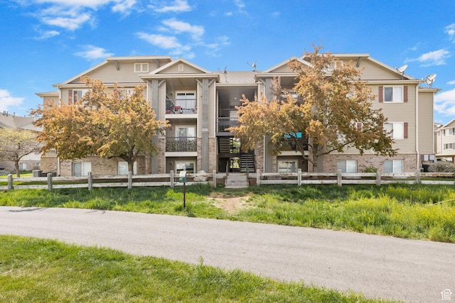 view of building exterior with a fenced front yard and stairway