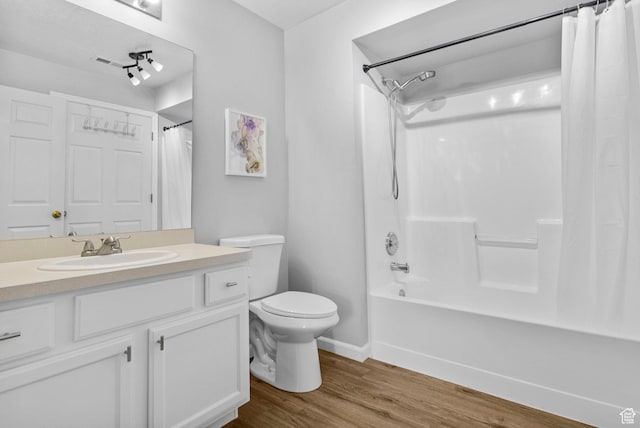 full bathroom featuring wood finished floors, toilet, shower / bathtub combination with curtain, vanity, and baseboards