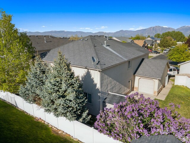8392 S Oak Vista Dr, West Jordan, UT 84081 - view of side of property with a garage, stucco siding, a shingled roof, a mountain view, and a residential view