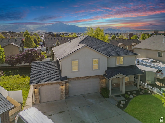 8392 S Oak Vista Dr, West Jordan, UT 84081 - view of front of house with stone siding, a garage, fence, and a mountain view