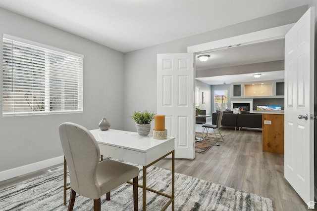 8392 S Oak Vista Dr, West Jordan, UT 84081 - office featuring light wood-style flooring, baseboards, and a glass covered fireplace