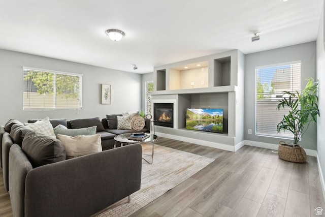 8392 S Oak Vista Dr, West Jordan, UT 84081 - living room with a glass covered fireplace, plenty of natural light, wood finished floors, and baseboards
