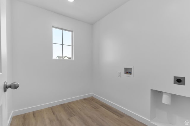 washroom with electric dryer hookup, washer hookup, baseboards, and wood finished floors