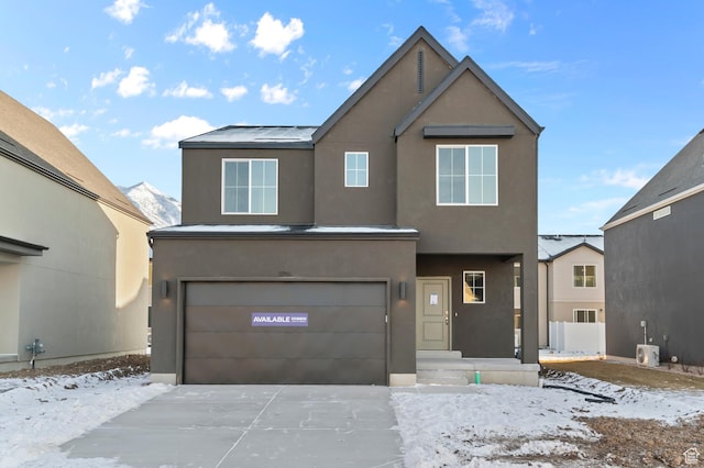 traditional home with an attached garage, stucco siding, and concrete driveway
