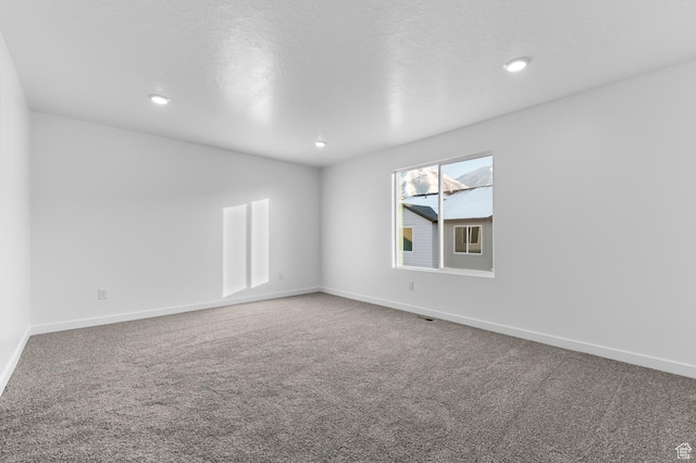 carpeted empty room with baseboards and recessed lighting