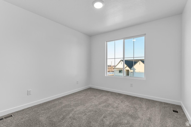 carpeted empty room featuring baseboards