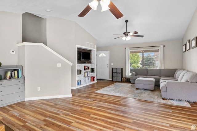 living room with a ceiling fan, wood finished floors, high vaulted ceiling, and baseboards