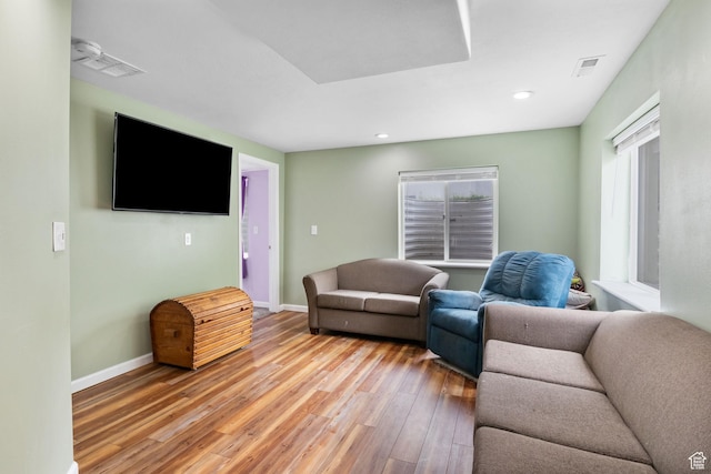 living room with light wood-style flooring, baseboards, and recessed lighting