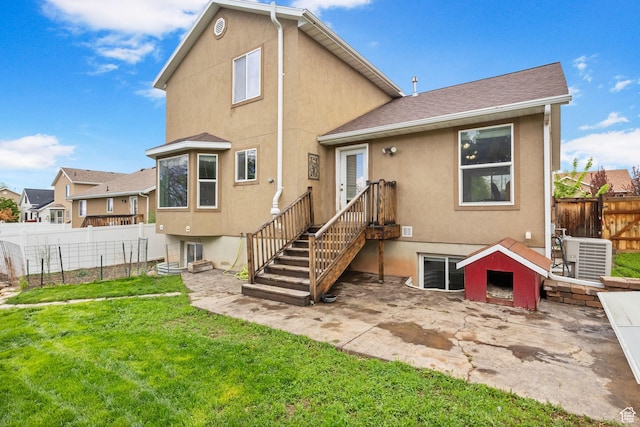 back of property with central air condition unit, stucco siding, a patio area, and roof with shingles