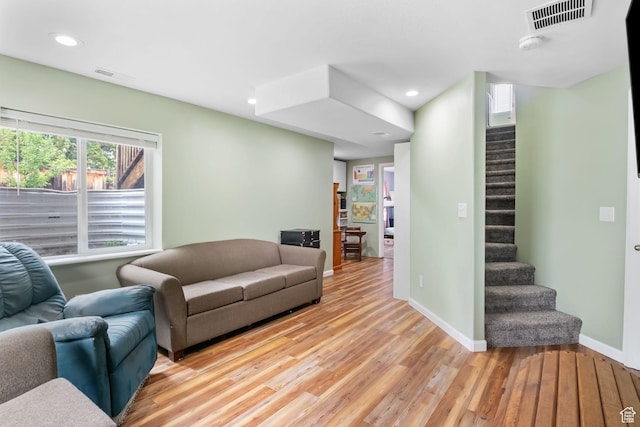 living room featuring light wood-style floors, stairway, baseboards, and recessed lighting
