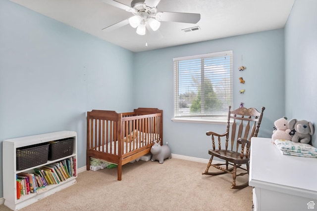bedroom featuring carpet flooring, baseboards, ceiling fan, and a crib