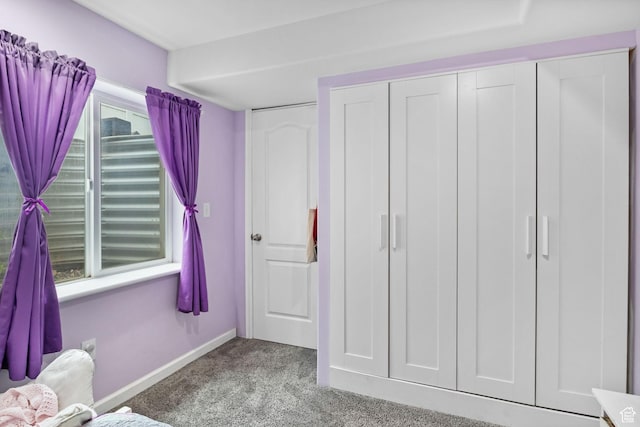 bedroom with carpet, baseboards, and a closet
