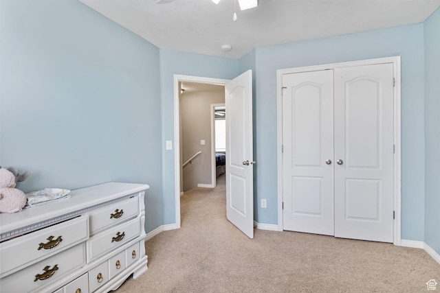 bedroom with light carpet, baseboards, a closet, and ceiling fan