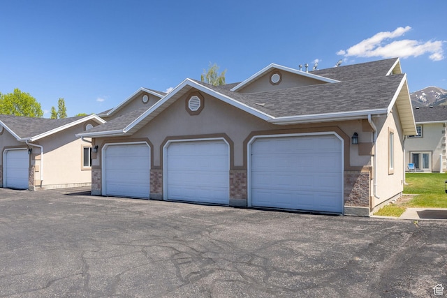 view of front facade featuring stucco siding and roof with shingles