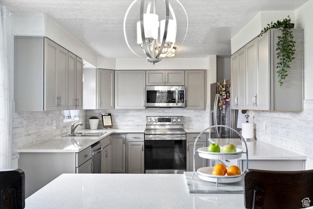 1471 W 1460 N, Provo, UT 84604 - kitchen with gray cabinetry, appliances with stainless steel finishes, a sink, a chandelier, and a textured ceiling