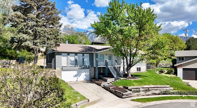 9977 S Lannae Dr E, Sandy, UT 84094 - view of front facade featuring concrete driveway, stairs, a garage, a front yard, and brick siding