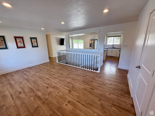 9977 S Lannae Dr E, Sandy, UT 84094 - unfurnished room with wood finished floors, recessed lighting, and baseboards