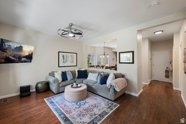 living area with a ceiling fan, a chandelier, wood finished floors, and baseboards