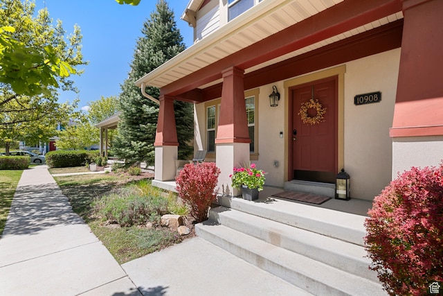 doorway to property featuring stucco siding and a porch