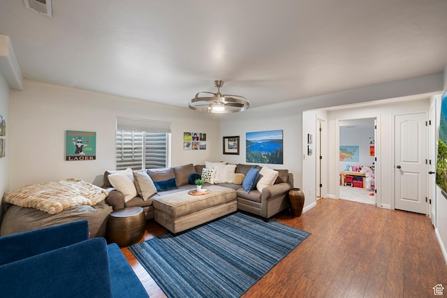 living area with wood finished floors, a ceiling fan, and baseboards