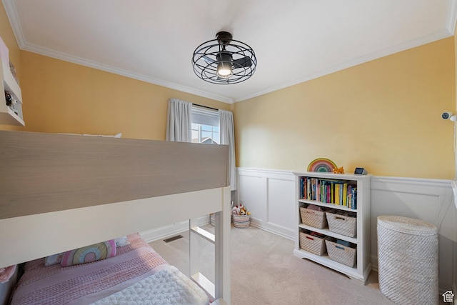 bedroom featuring ornamental molding, carpet flooring, and a wainscoted wall