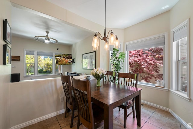 dining space featuring tile patterned floors, a chandelier, and baseboards