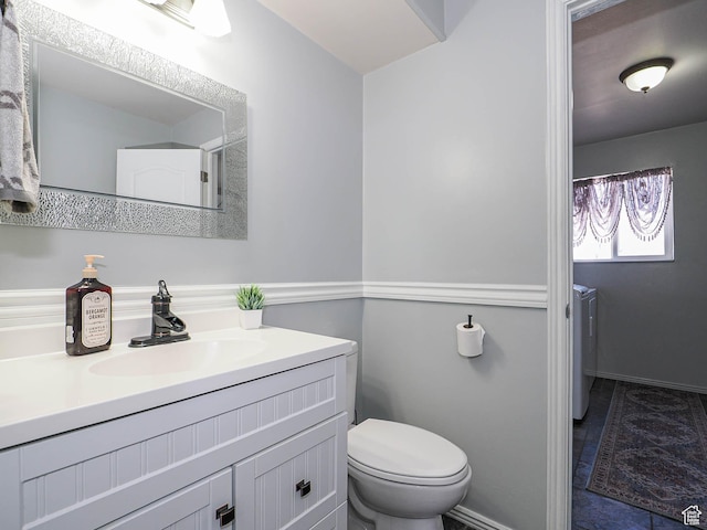 bathroom featuring washer and dryer, vanity, and toilet
