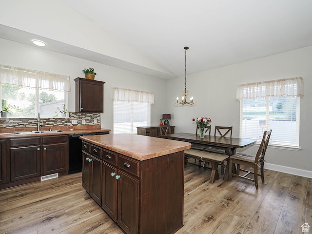 kitchen featuring a sink, light wood-style floors, lofted ceiling, plenty of natural light, and dark brown cabinets