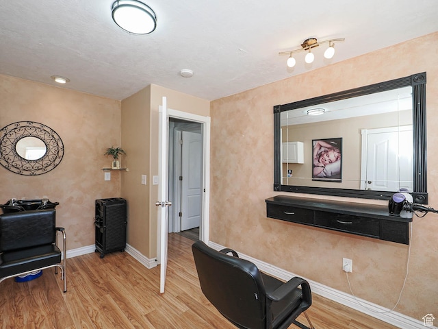 exercise room featuring wood finished floors and baseboards