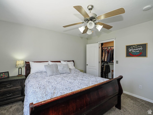 carpeted bedroom featuring a walk in closet, ceiling fan, baseboards, and a closet