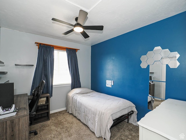 carpeted bedroom featuring an office area and ceiling fan