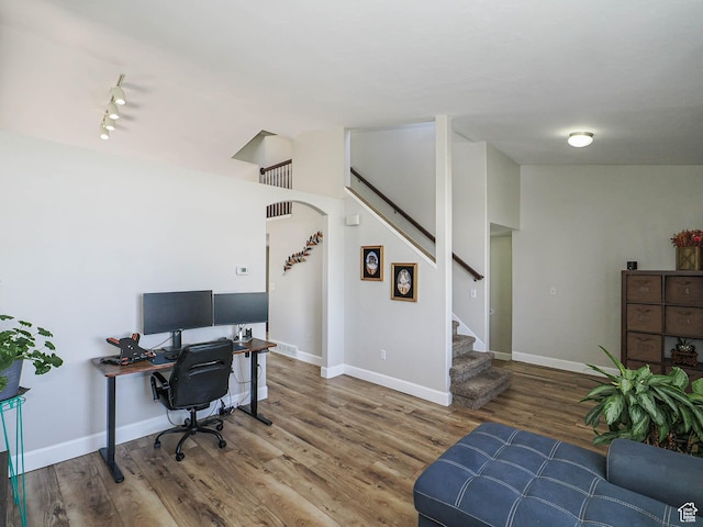 office featuring wood finished floors, baseboards, and track lighting